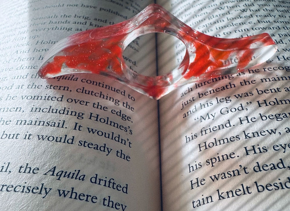 An open book with a resin bat-shaped bookmark